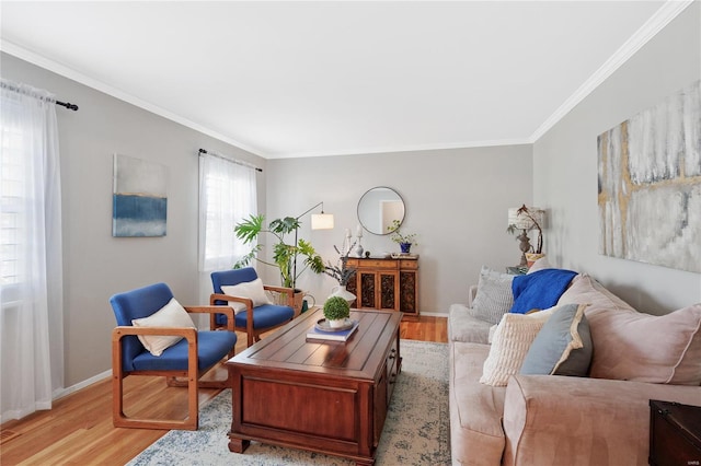 living room with crown molding, baseboards, and light wood finished floors