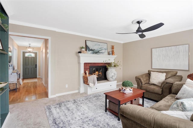 carpeted living area featuring baseboards, ornamental molding, and a fireplace