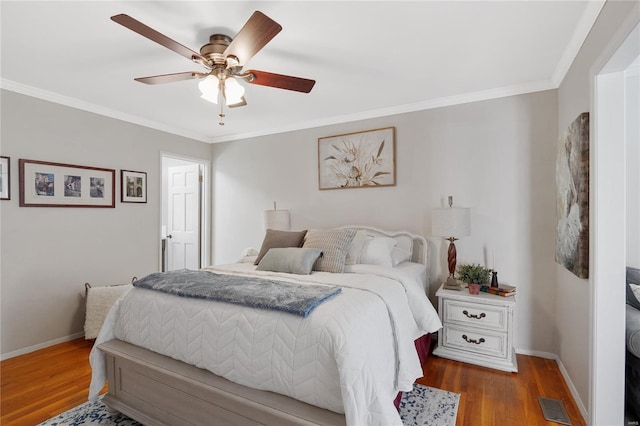 bedroom featuring baseboards, ornamental molding, and wood finished floors