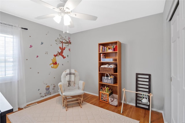 sitting room featuring baseboards, ceiling fan, wood finished floors, and visible vents