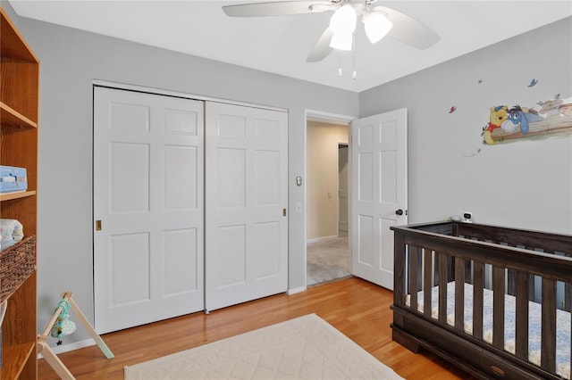 bedroom featuring light wood-style floors, baseboards, ceiling fan, and a closet