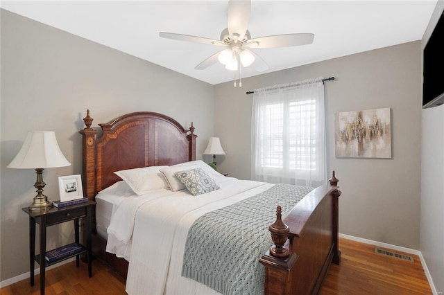 bedroom featuring visible vents, baseboards, and wood finished floors