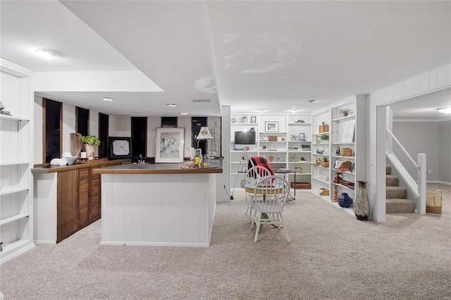 interior space featuring light colored carpet, bar area, and stairway