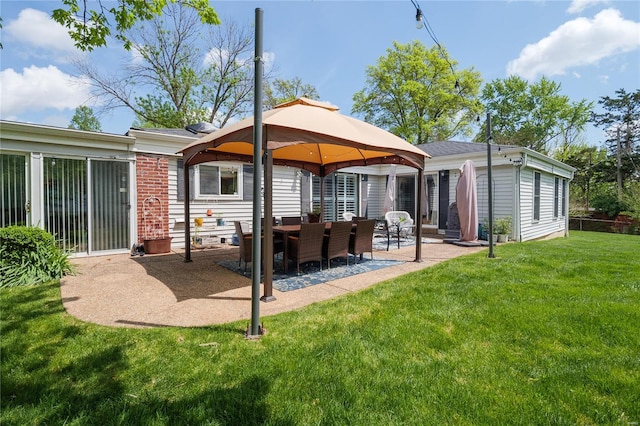 rear view of property with a patio, a lawn, and a gazebo