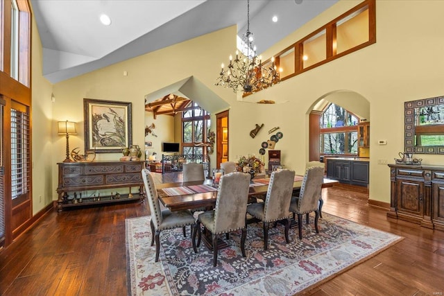 dining room with arched walkways, hardwood / wood-style flooring, high vaulted ceiling, and a wealth of natural light