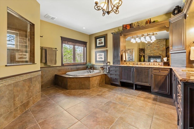 bathroom featuring a bath, visible vents, tile patterned flooring, vanity, and a chandelier