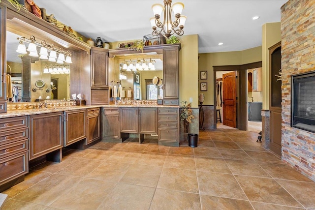 full bath with vanity, tile patterned flooring, and a notable chandelier