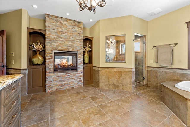 bathroom with a multi sided fireplace, tile patterned floors, a bath, and a stall shower