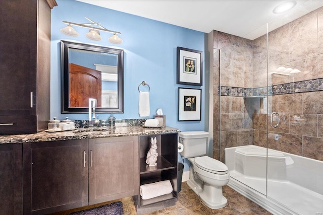 full bathroom with vanity, baseboards, toilet, and a shower stall