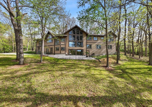 rear view of house with a patio and a yard