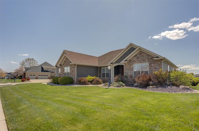 view of front facade with a garage, stone siding, and a front lawn