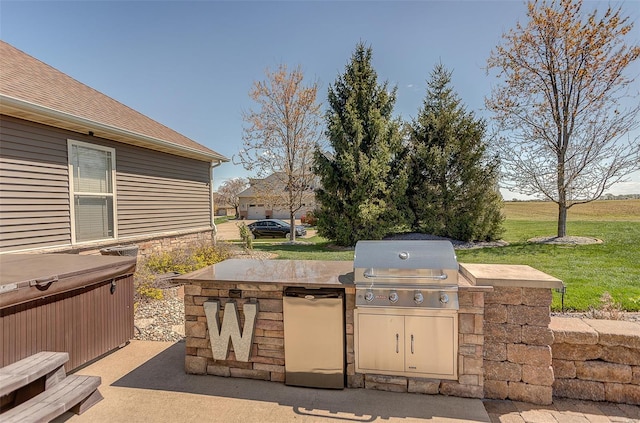 view of patio / terrace featuring a hot tub, exterior kitchen, and area for grilling