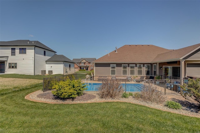 pool with a patio area, fence, and a yard