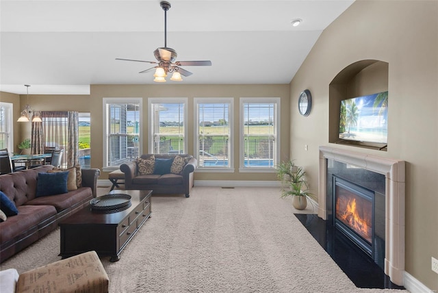 living area with a fireplace with flush hearth, carpet floors, baseboards, and a wealth of natural light