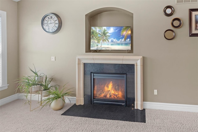 details featuring a fireplace with flush hearth, baseboards, visible vents, and carpet