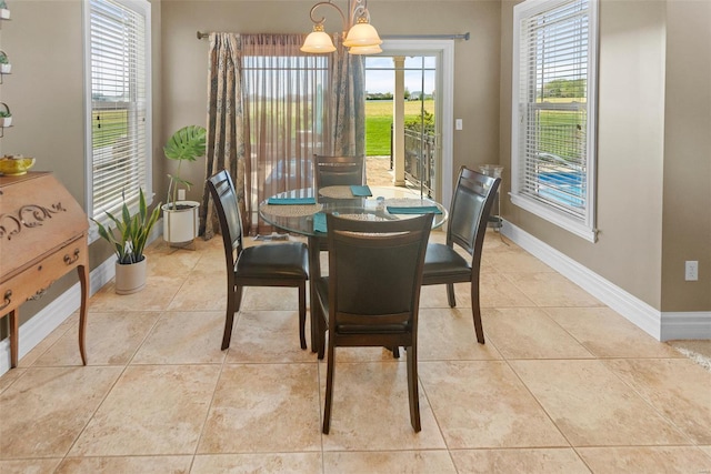dining space featuring a chandelier, baseboards, and light tile patterned floors