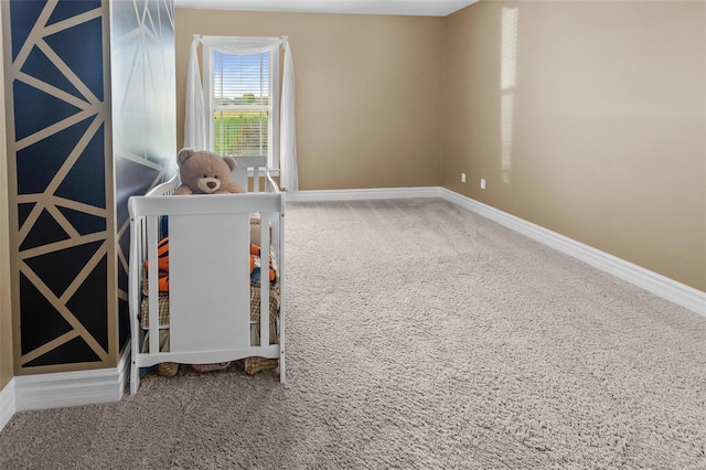 carpeted empty room featuring baseboards