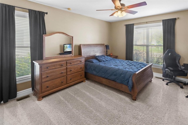bedroom with visible vents, baseboards, and light carpet