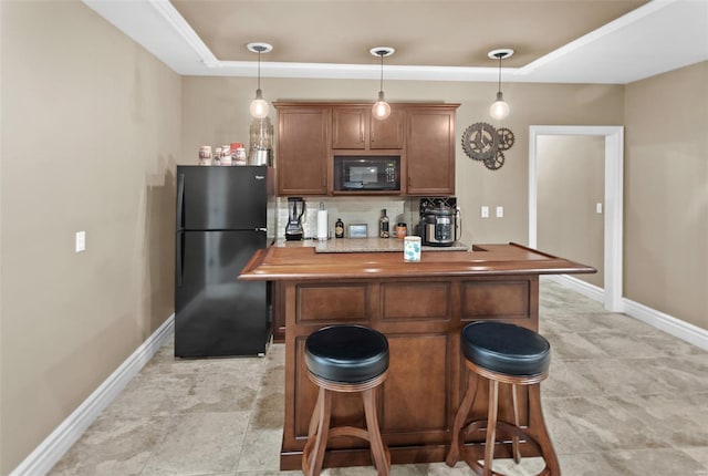 kitchen with decorative light fixtures, a breakfast bar, baseboards, and black appliances