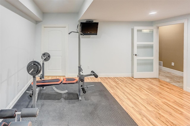 exercise room with baseboards, wood finished floors, visible vents, and recessed lighting