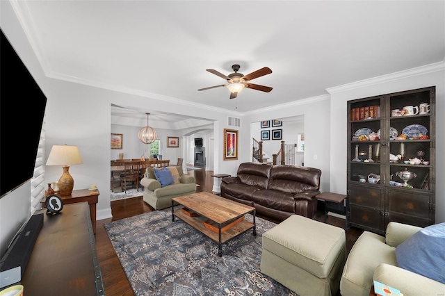 living area with ceiling fan, visible vents, crown molding, wood finished floors, and baseboards