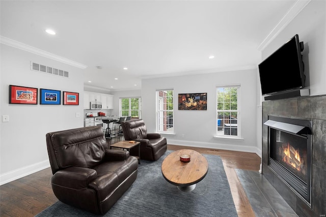 living area featuring visible vents, ornamental molding, and a fireplace