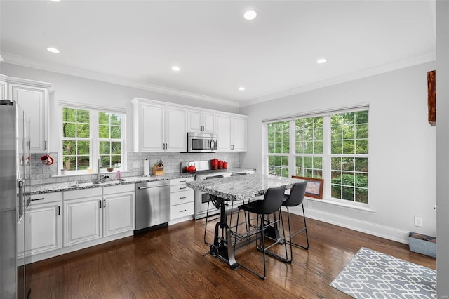 kitchen with a sink, white cabinets, stainless steel appliances, and a wealth of natural light