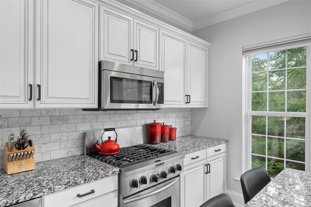 kitchen featuring light stone countertops, stainless steel appliances, white cabinetry, tasteful backsplash, and ornamental molding