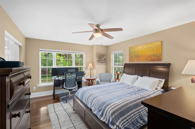 bedroom with baseboards, dark wood-style floors, multiple windows, and ceiling fan