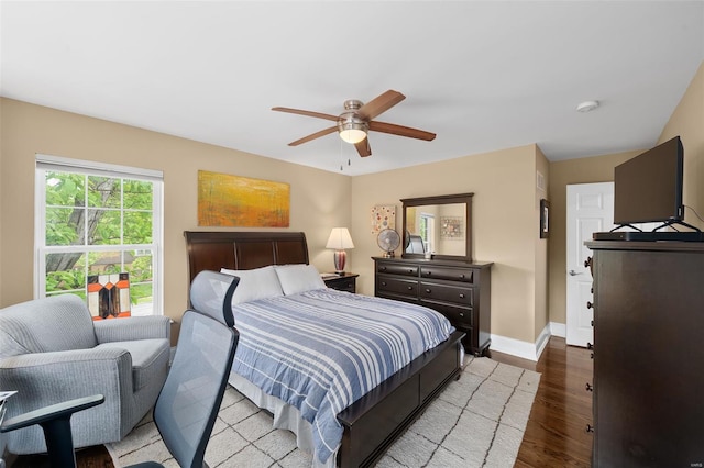 bedroom with a ceiling fan, baseboards, and wood finished floors