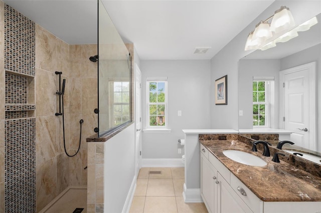 full bath with baseboards, walk in shower, tile patterned flooring, and vanity