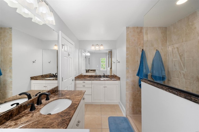 bathroom with a sink, a walk in shower, tile patterned floors, and two vanities
