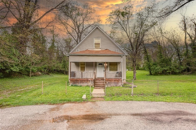 view of front of house featuring a porch, fence, and a front yard