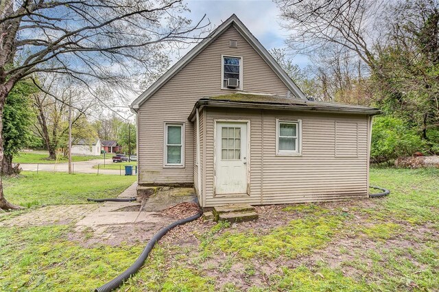 rear view of property featuring a lawn