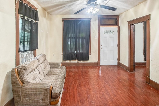 foyer entrance featuring ceiling fan, baseboards, wood finished floors, and a textured ceiling