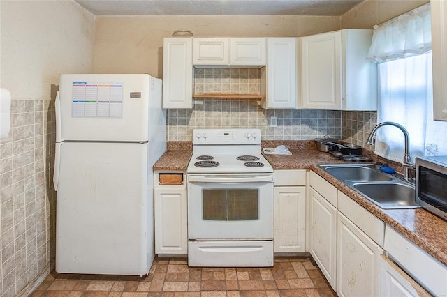 kitchen with white cabinets, tile walls, white appliances, and a sink