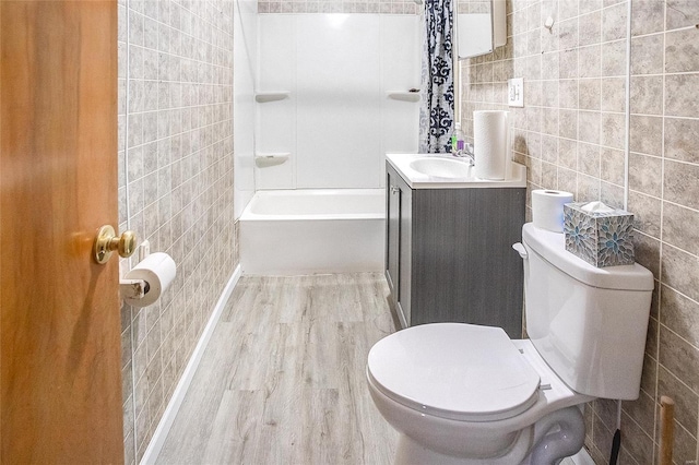 full bathroom with tile walls, wood finished floors, vanity, and toilet