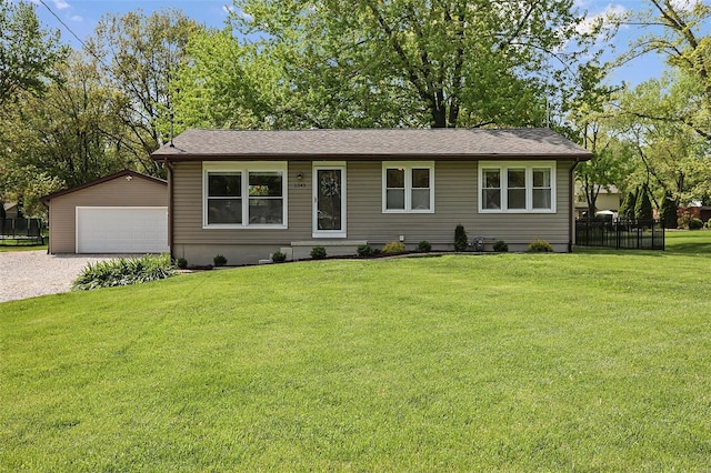 single story home featuring a garage, fence, an outbuilding, and a front lawn