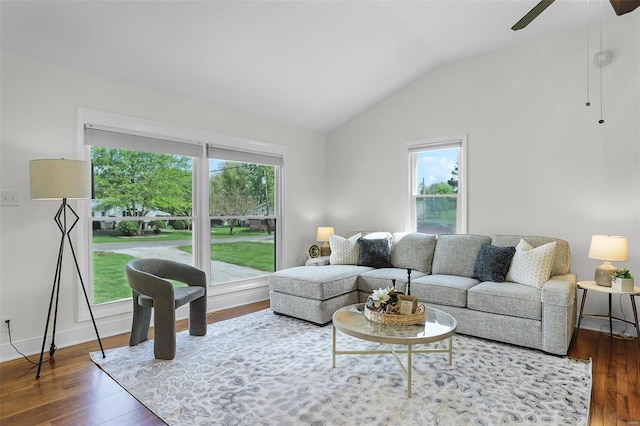 living room featuring baseboards, ceiling fan, vaulted ceiling, and wood finished floors