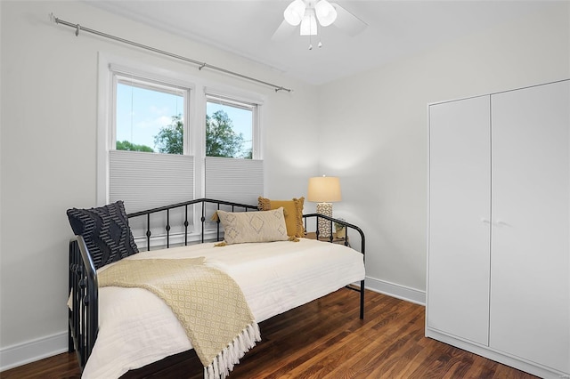 bedroom with baseboards, a ceiling fan, a closet, and wood finished floors