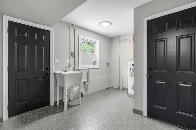 laundry area featuring water heater and a sink