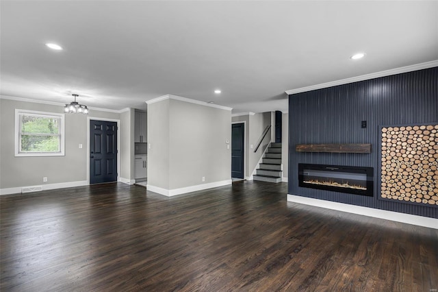 unfurnished living room with a notable chandelier, wood finished floors, and crown molding