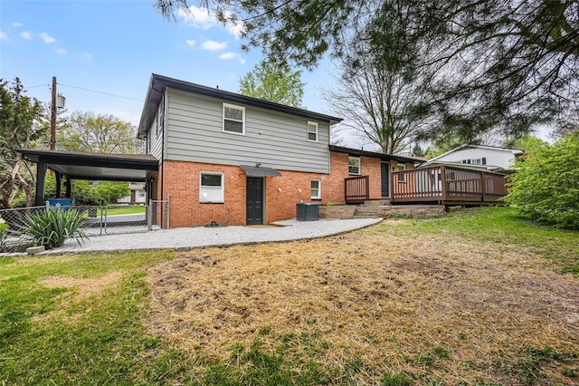 back of house featuring fence, a wooden deck, a lawn, and brick siding