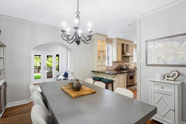 dining area featuring baseboards, french doors, arched walkways, dark wood finished floors, and a notable chandelier