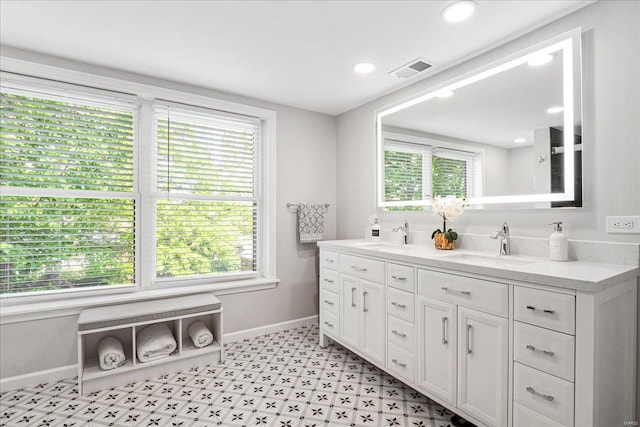 full bathroom featuring baseboards, a sink, visible vents, and a healthy amount of sunlight