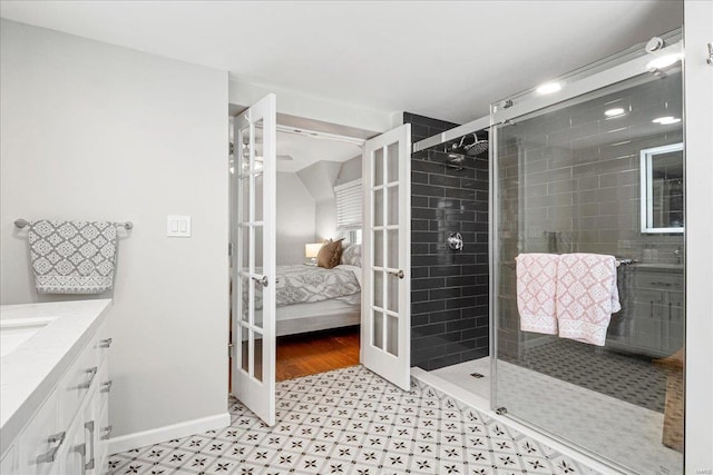 ensuite bathroom featuring vanity, tile patterned floors, french doors, ensuite bathroom, and a stall shower