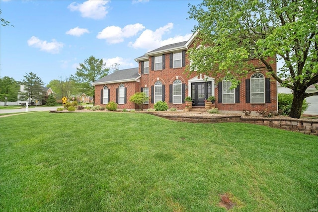 colonial home featuring brick siding and a front lawn