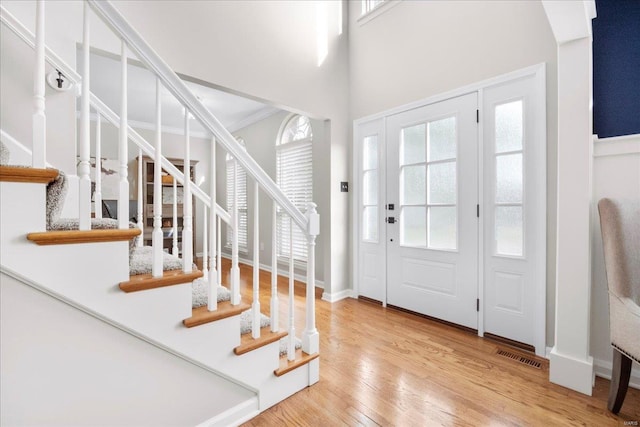 entrance foyer featuring visible vents, stairway, and wood finished floors