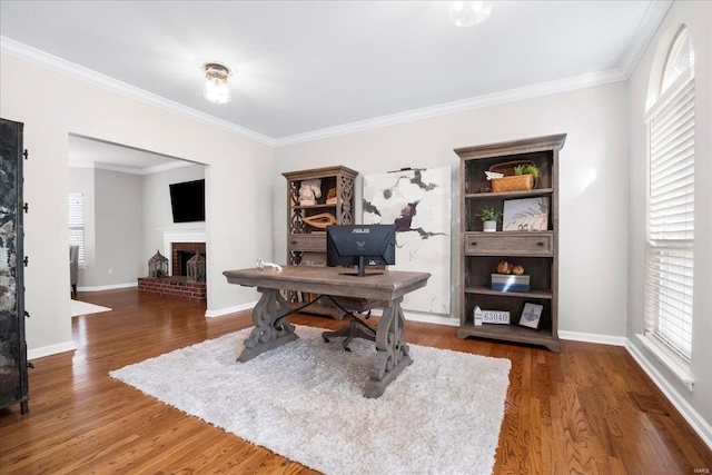 office featuring baseboards, wood finished floors, ornamental molding, and a fireplace
