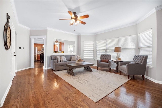 living room featuring baseboards, wood finished floors, ceiling fan, and plenty of natural light